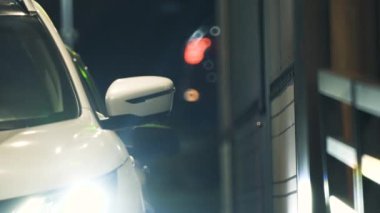 Şoför, gece vakti şehirdeki bir fast food restoranından yemek sipariş etmek için satıcıdan yiyecek alıyor..