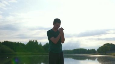 Genç sporcu antrenmandan önce ısınır. Nehir kenarında açık havada antrenman yapıyor. Buharlı çekim.