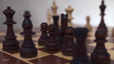 Satranç tahtasındaki siyah ve beyaz tahta satranç başlangıç pozisyonlarında oyuna hazır. Beyaz arka plan. - Yakın çekim. Kameranın yatay hareketi, doli çekim.