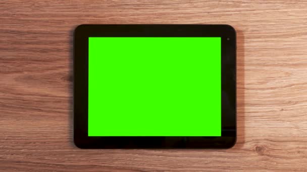 木製のテーブルの上に緑の画面を持つ白い水平タブレットデバイスを使用して 男の手の上のビュー — ストック動画
