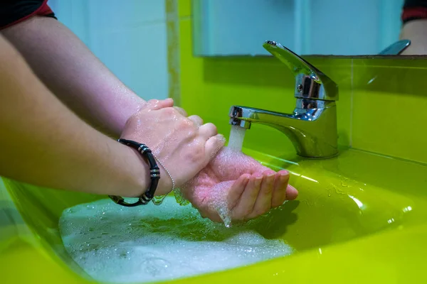 Ellerimi doğru dürüst yıkıyorum. Hijyen konsepti. Sabun ve suyla ovmak. Yeşil lavabo.