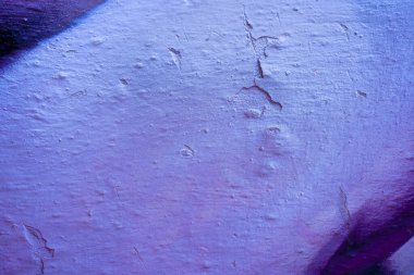 Kırık bir duvarda mavi ve mor soyut boya. Grafiti dokusunun yakın çekimi. Sokak sanatı arka planı.