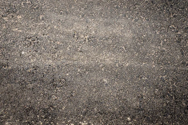 砂に覆われたアスファルトの道路のテクスチャ — ストック写真
