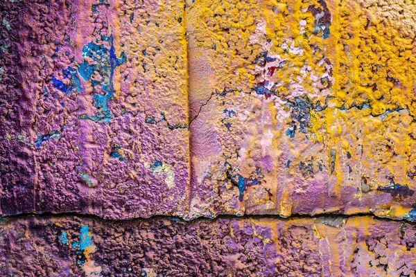 コンクリートブロック壁の質感の粗いコンクリート上の多色の紫色のオレンジの落書きのクローズアップ ストリートアートの背景 — ストック写真