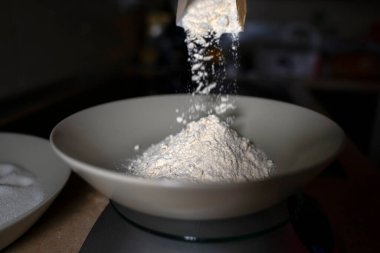 Derin bir tabağa un dök. Koyu arkaplan.