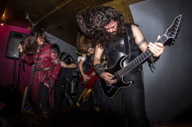 Malaga, İspanya - 09 Mayıs 2015: Sakallı bir adam, kadın bir vokalist ve uzun saçlı sarışın bir rock 'çının yanında gitar çalıyor. Özür dilerim, heavy metal grubu konser veriyor. Balık bakışı.