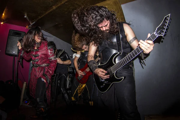 Malaga, İspanya - 09 Mayıs 2015: Sakallı bir adam, kadın bir vokalist ve uzun saçlı sarışın bir rock 'çının yanında gitar çalıyor. Özür dilerim, heavy metal grubu konser veriyor. Balık bakışı.