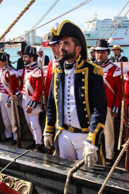 Malaga, İspanya - 26 Ekim 2014: Mürettebatıyla birlikte 18. yüzyıl Kraliyet Donanması 'nın kaptanı. Arkada kraliyet deniz piyadeleri üniformalı, kırmızı ceketli ve siyah şapkalı insanlar vardı. Canlandırıcılar.
