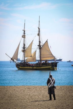 Malaga, İspanya - 26 Ekim 2014: Brig La Grace kıyının yanında. Plajdaki Napolyon askeri. 1812 'deki İngiliz çıkartmasının tarihi yeniden canlandırması. Kraliyet Donanması bir korsan üssüne saldırdı..