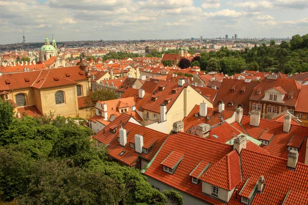 Çatılar dolusu ev, binalar ve Aziz Niklas Kilisesi kubbesi. Skyline ve Schonborn Garden. Prag Kalesinden Görünüm (Prazsky Hrad).