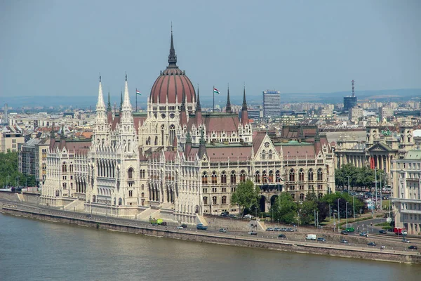 Budapeşte, Macaristan - 11 Mayıs 2012: Macaristan Parlamentosu (Orszaghaz) ve Tuna nehrinin yanındaki diğer binalar. Sabahları manzara manzarası.