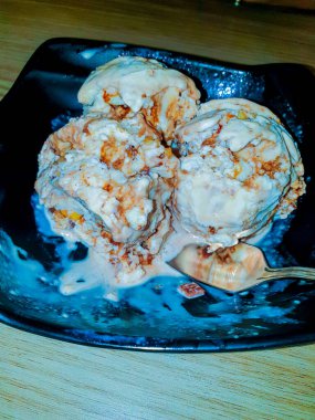 Karamela dondurması. Siyah tabakta tuzlu karamel dondurma..