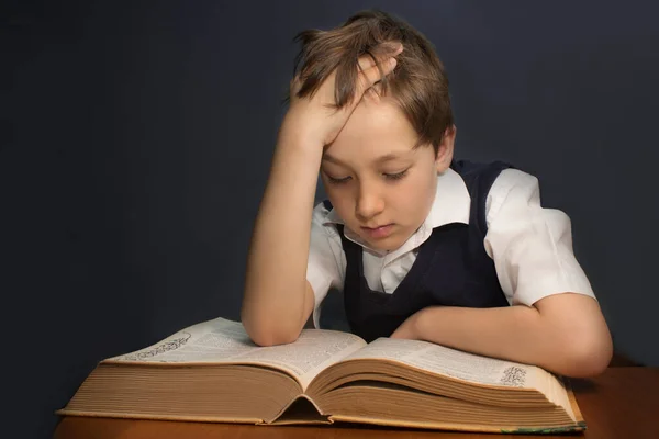 Kitapları olan genç adam çalışma masasında oturuyor. Ev eğitimi kavramı