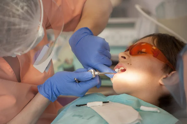 Stomatoloji ve sağlık konsepti, diş sağlığı kliniğindeki genç erkek hastaların diş tedavisi. Pamuk çubukları yerleştir