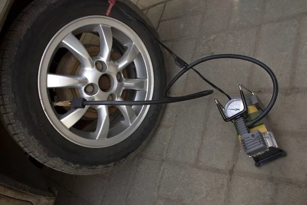 electric pump inflates the wheel in car.