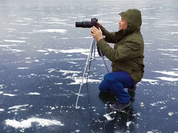 Fotoğrafçı buzda fotoğraf çekiyor. Kışın gölde.