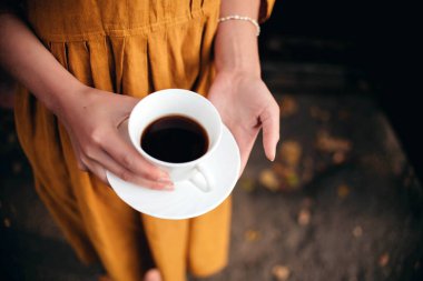  Female hands holding cup of coffee.A girl holding a mug with hot coffee. Atmospheric tranquil moment.