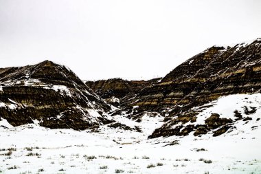 Çorak Topraklar 'ın tepelerine ve vadilerine kar yapışır. Drumheller Alberta, Kanada.
