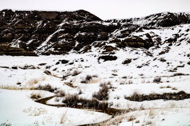Çorak Topraklar 'ın tepelerine ve vadilerine kar yapışır. Drumheller Alberta, Kanada.