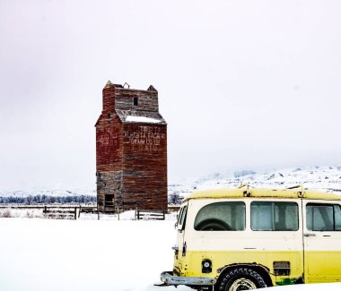 Tarihsel tahıl asansörü, karda eski traktörler ve kamyonlar. Dorothy, Alberta, Kanada