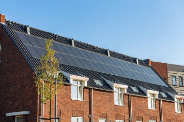 Güneşli bir günde evlerin çatısındaki güneş panelleri