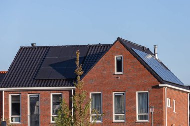 Güneşli bir günde evlerin çatısındaki güneş panelleri