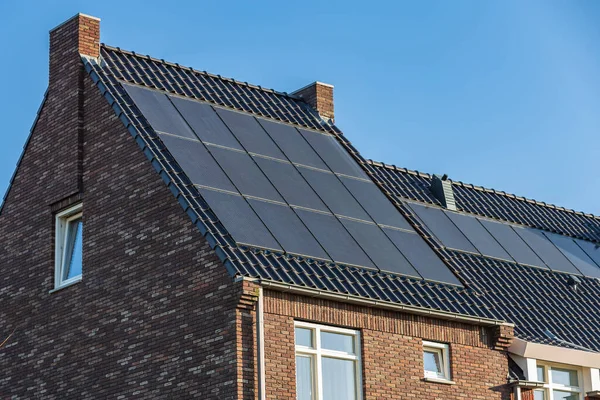 Güneşli bir günde evlerin çatısındaki güneş panelleri
