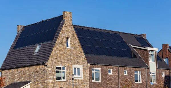 Güneşli bir günde evlerin çatısındaki güneş panelleri