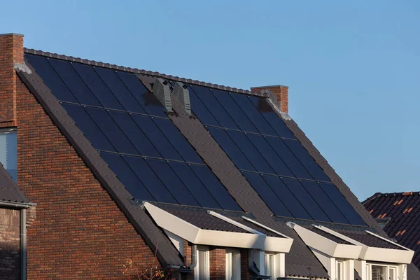 Güneşli bir günde evlerin çatısındaki güneş panelleri