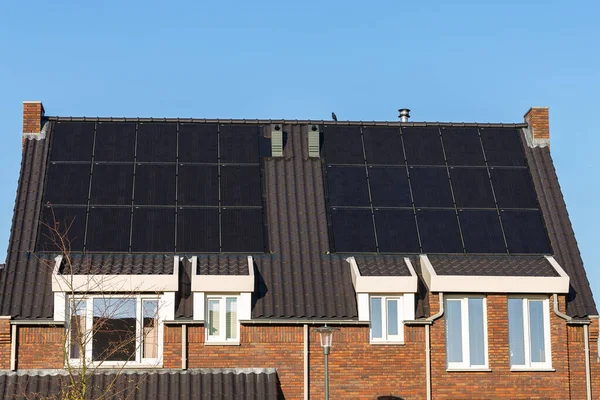 Güneşli bir günde evlerin çatısındaki güneş panelleri