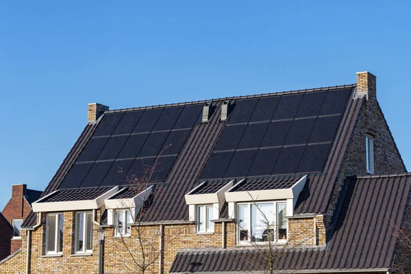 Güneşli bir günde evlerin çatısındaki güneş panelleri