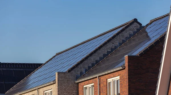 Güneşli bir günde evlerin çatısındaki güneş panelleri