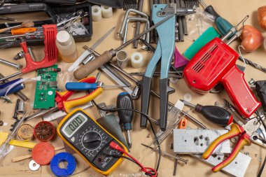 Masaüstüne bir sürü araç ve malzeme rastgele dağılmış..