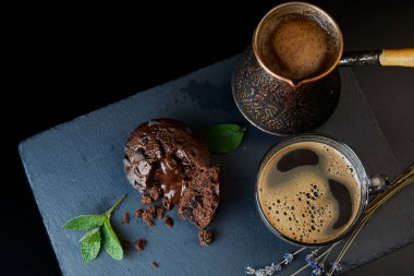 Lezzetli bir çikolatalı kek, bir fincan sade kahve, kremalı kahve. Naneli ve lavantalı..