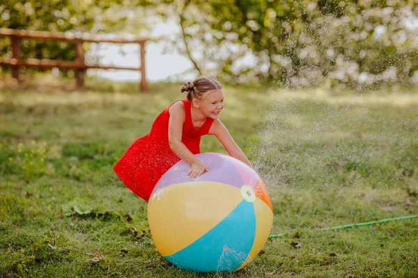 Little girl playing with water splashing ball