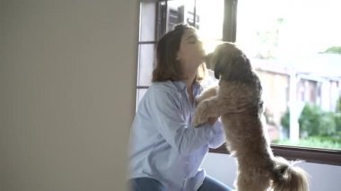 Genç kız odasında köpeğiyle oynuyor..