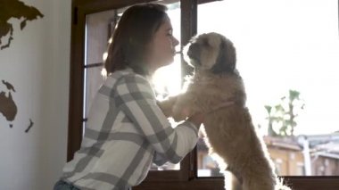Genç kız odasında köpeğiyle oynuyor..