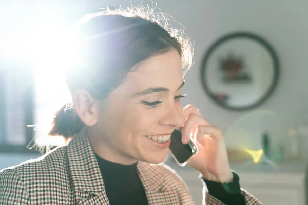 İş telefonundan konuşan çekici bir genç kızın yakın çekimi. Uzaklaştırma.