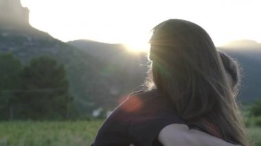 Lezbiyen kızlar gün batımında sarılıp öpüşüyor. LGBT