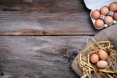 Ahşap arka planda yumurtalar ve saman manzarası. 