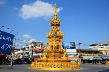 Tayland, Chiang Rai 'deki bir trafik adasında altın saat kulesi.