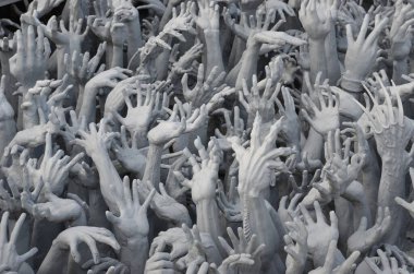 Kayıp insanların elleri cehennemden çıkıyor. Wat Rong Khon, Chiang Rai 'deki güzel beyaz tapınak.