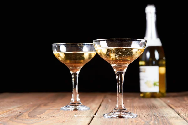 Champagne in two glasses on wooden table — Stock Photo, Image