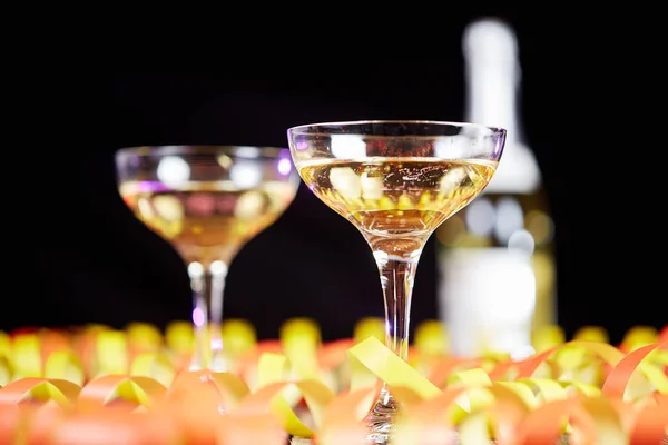 Streamers decoration on table and glass of champagne — Stock Photo, Image