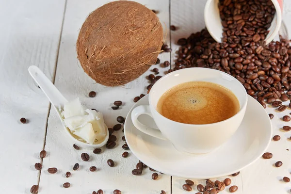 Grãos de café e coco na mesa branca — Fotografia de Stock
