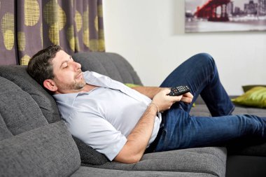 Beyaz adam evde kanepede oturup tv izliyor