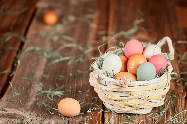 Easter basket en rauwe eieren op houten tafel — Stockfoto