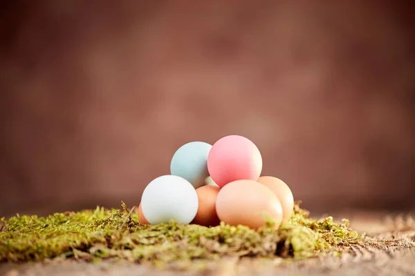 Pastel huevos de Pascua en el musgo verde en la mesa —  Fotos de Stock