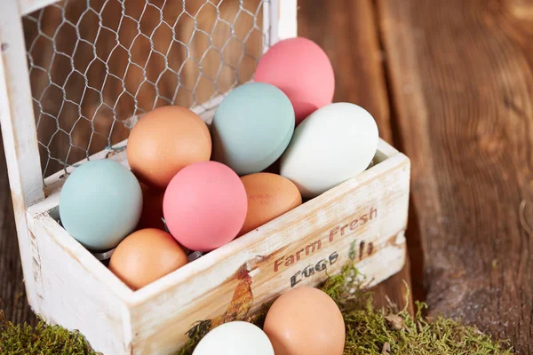 Pastel colored easter eggs in white wooden box — Stock Photo, Image