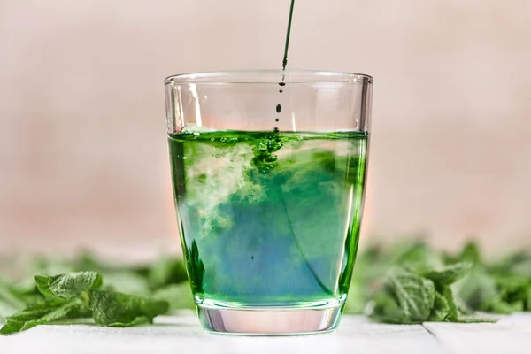 Green chlorophyll drink in glass with water Royalty Free Stock Images